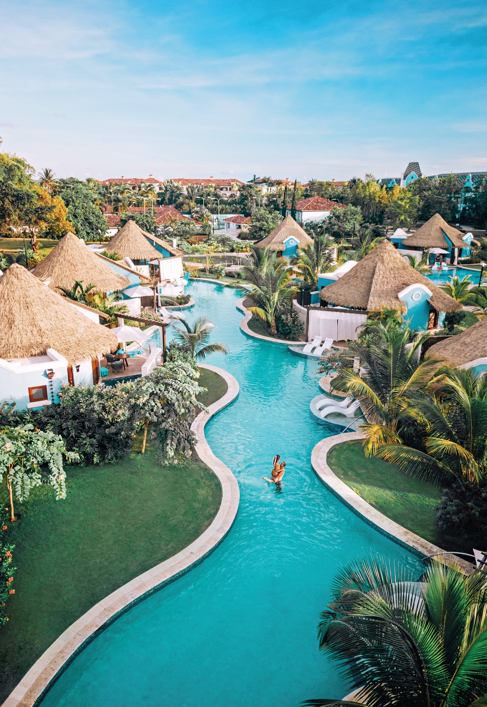 couple swimming in pool at sandals south coast resort