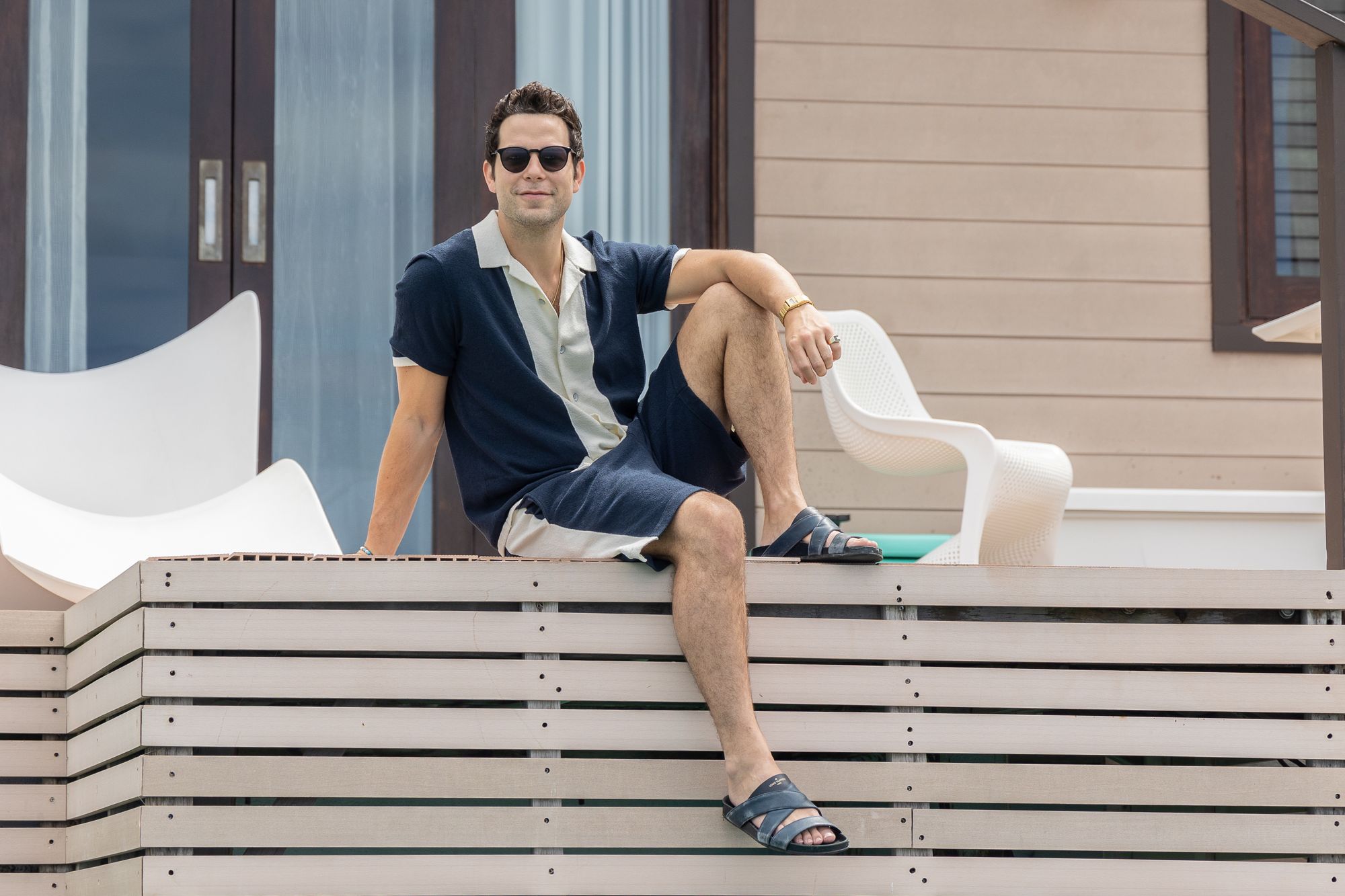 skylar astin sitting on private overwater bungalow at sandals south coast