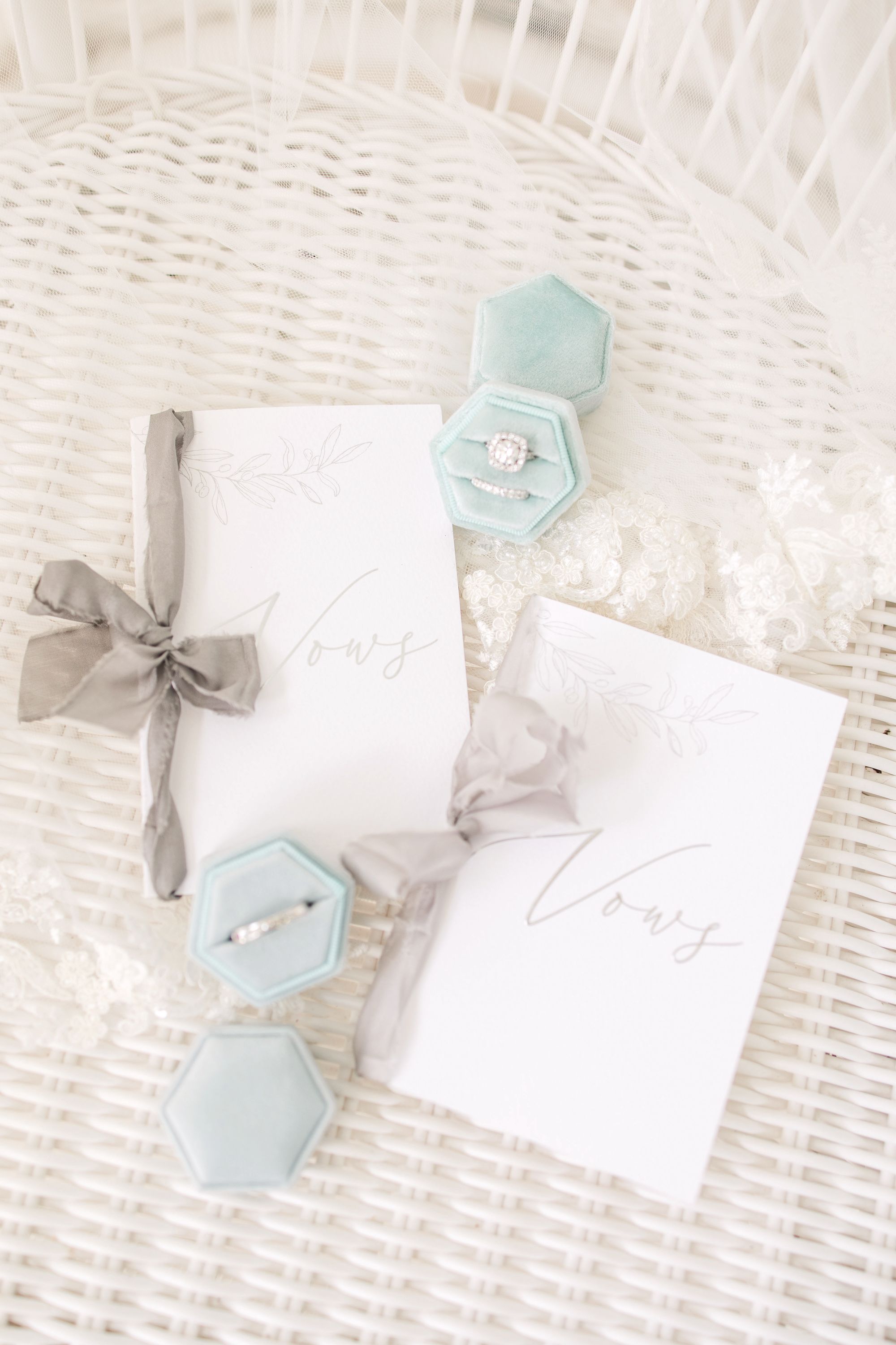 two vow cards and ring boxes white wicker