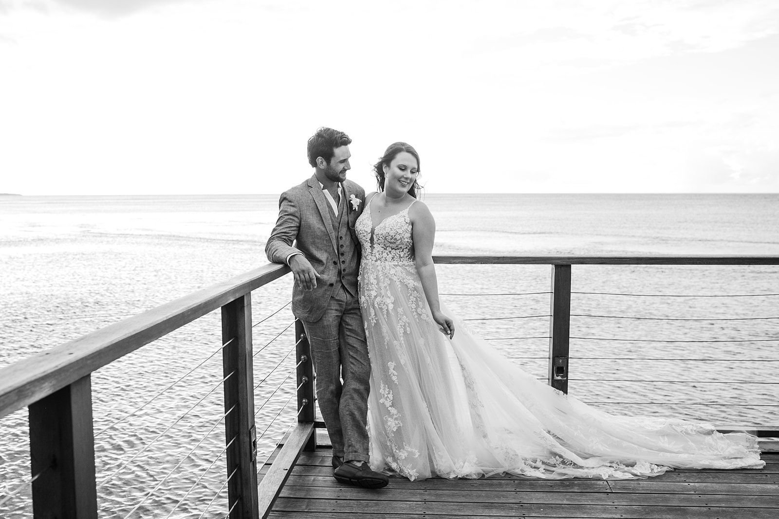 kirtsten and conor posing in their wedding clothes on a dock at sandals ochi