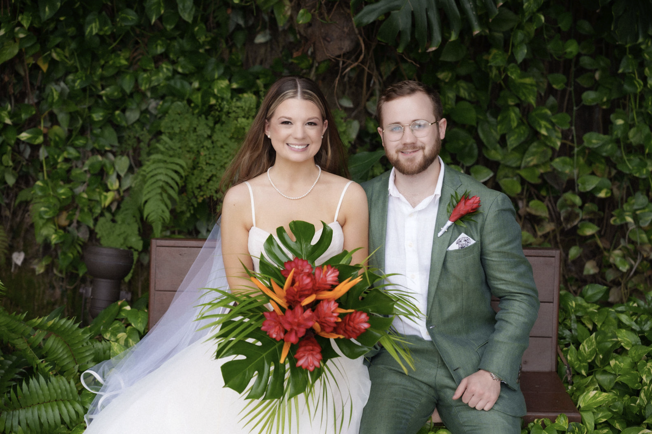 Hailey-and-caleb-sitting-on-bench-in-wedding-attire