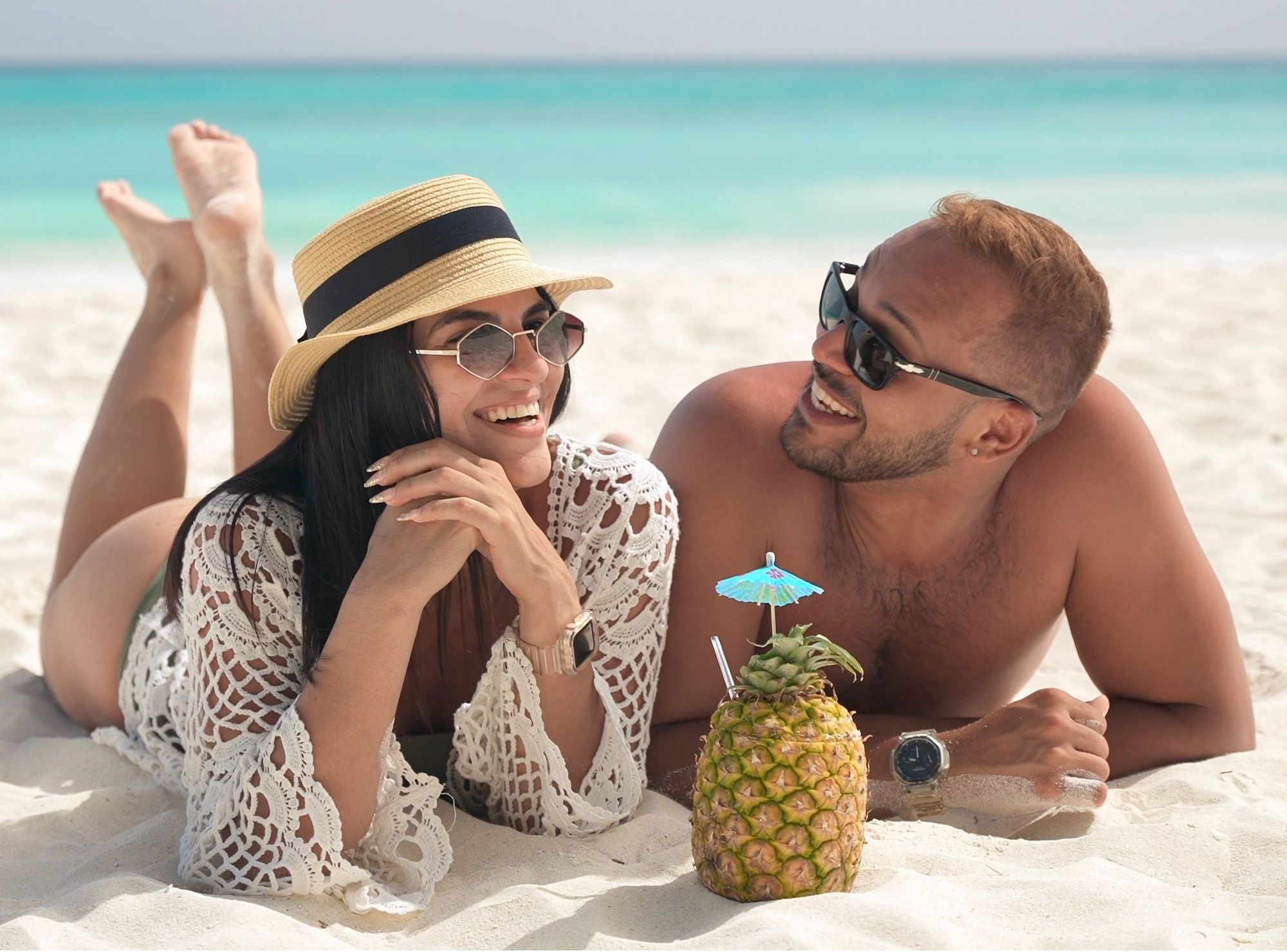 couple with pineapple on beach