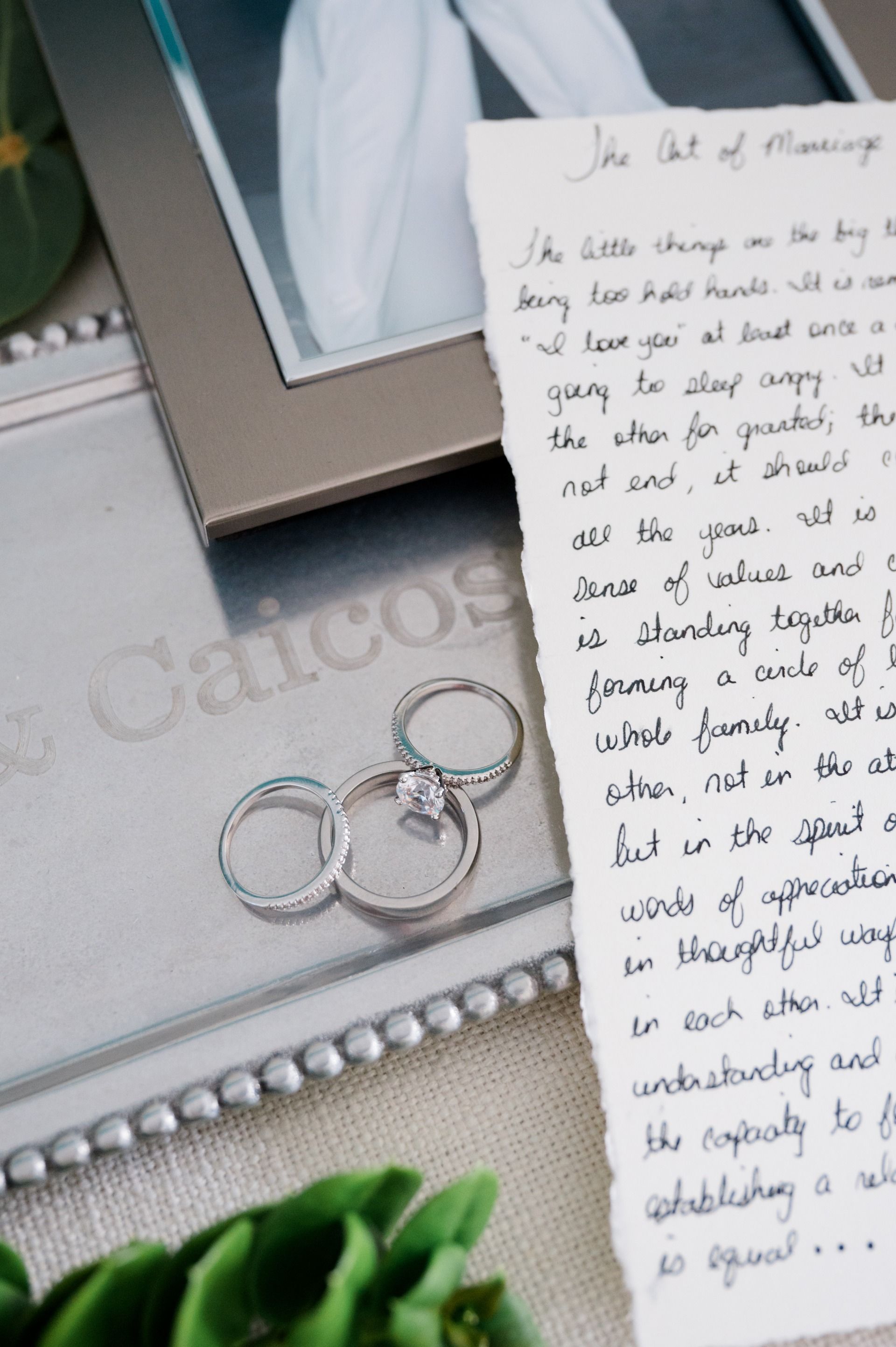 Engagement and wedding rings resting beside handwritten vows and keepsakes
